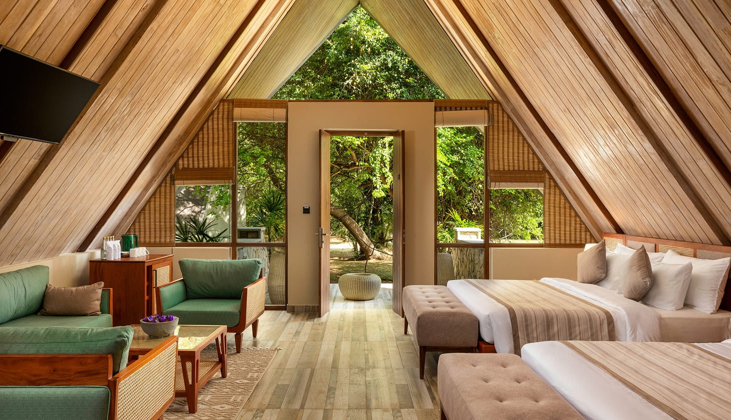 A bedroom with two beds and green hued furniture at a garden view villa at Oak Ray Liyya Water Villas Dambulla