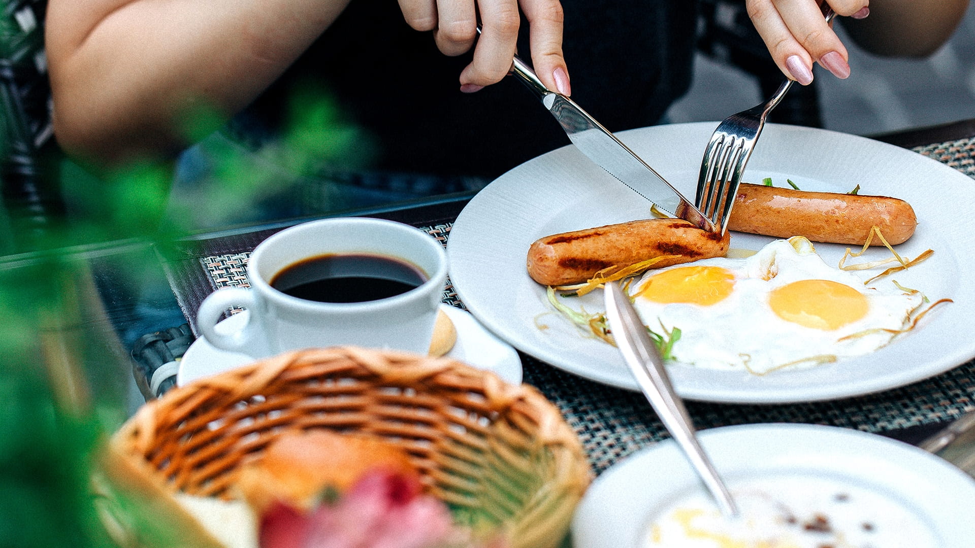 A female using utensils to have an English breakfast 