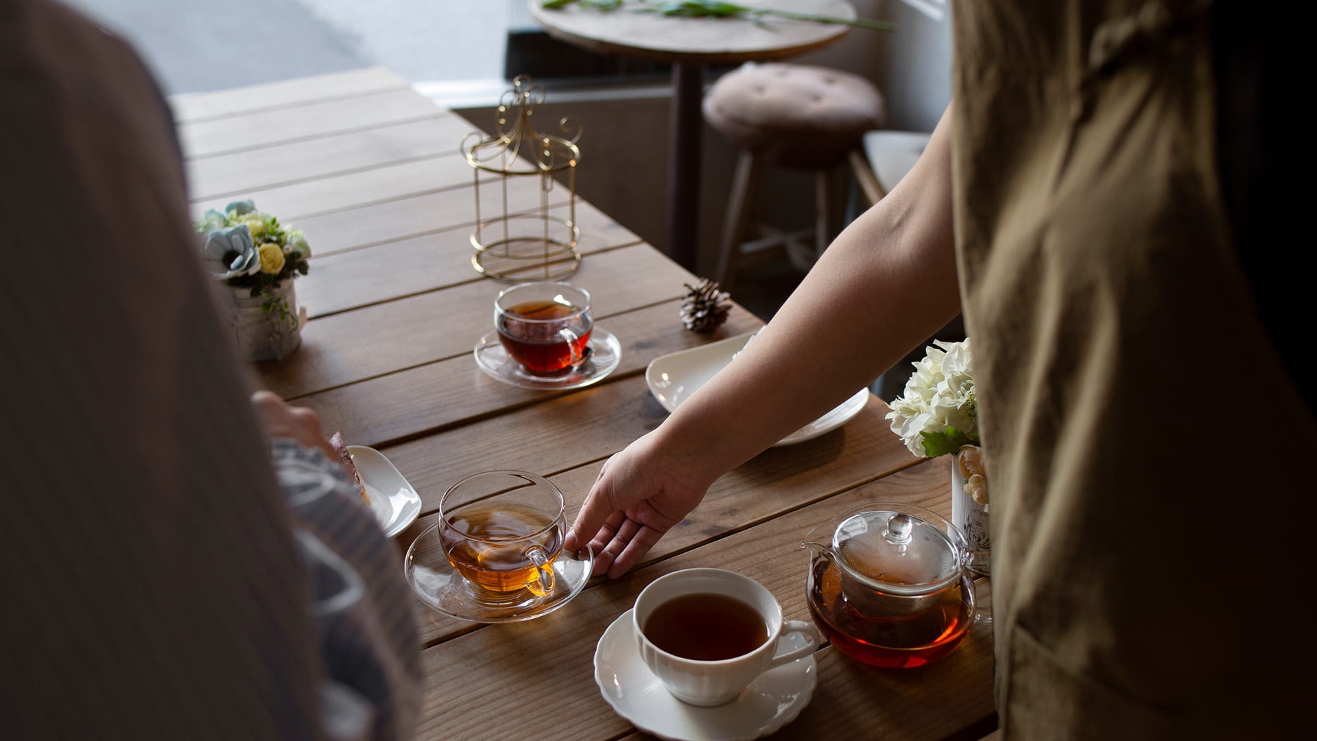 A cup of tea being served at a table with another cup already poured