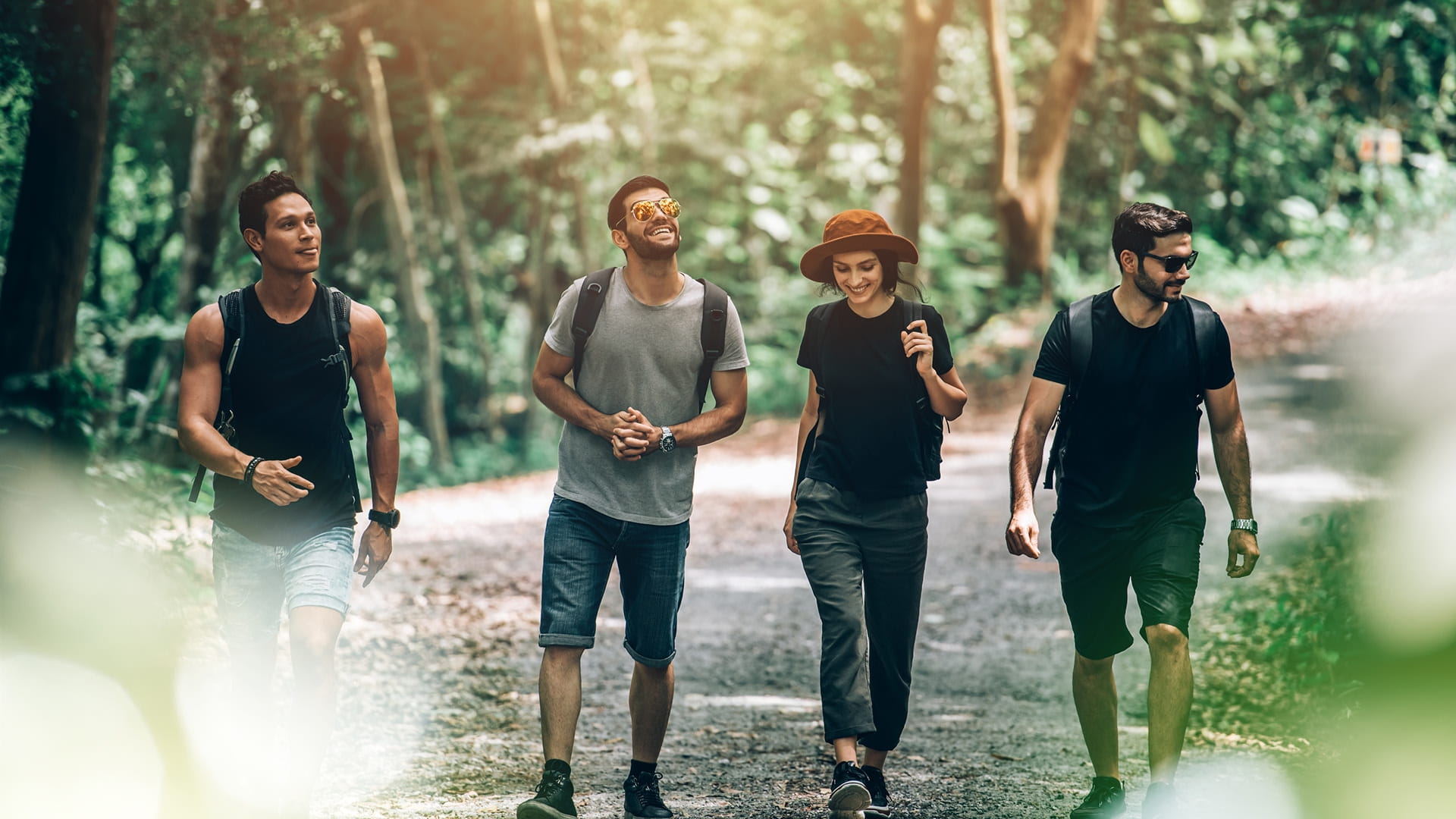 3 males and 1 female walking down a forest